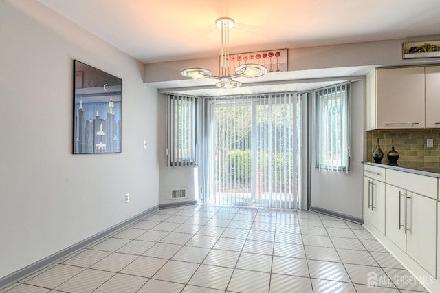 38 Silver Holw, North Brunswick, NJ 08902 - unfurnished dining area featuring healthy amount of natural light, baseboards, a chandelier, and light tile patterned floors