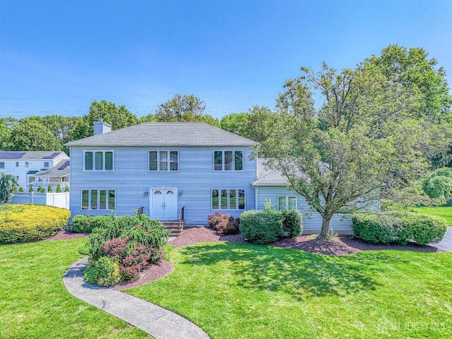 38 Silver Holw, North Brunswick, NJ 08902 - view of front facade featuring a front yard, a chimney, and french doors