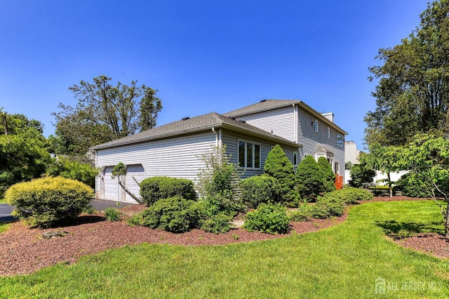 38 Silver Holw, North Brunswick, NJ 08902 - view of side of home featuring a chimney, a yard, an attached garage, and driveway