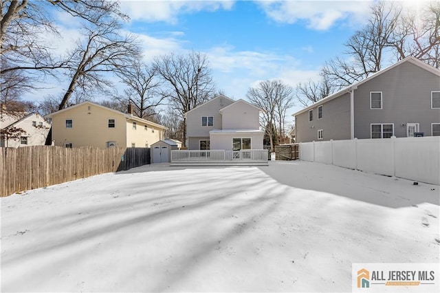 back of house with a storage shed, an outbuilding, and a fenced backyard