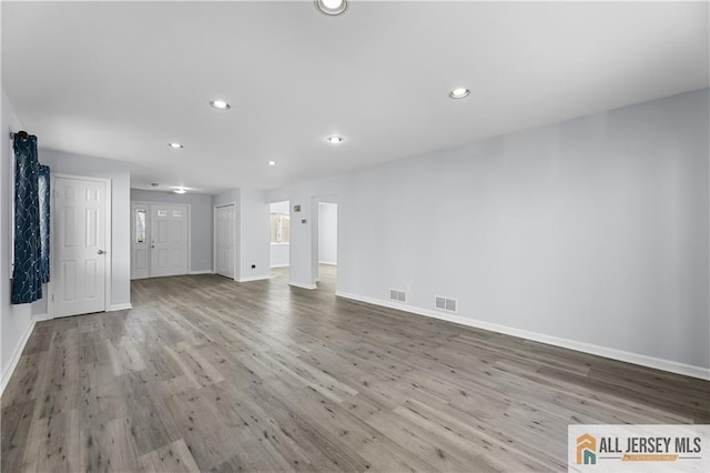 unfurnished living room featuring baseboards, wood finished floors, visible vents, and recessed lighting