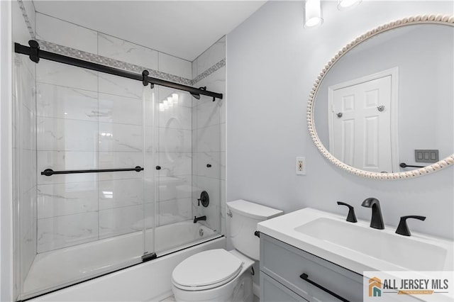 bathroom featuring toilet, bath / shower combo with glass door, and vanity