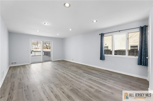 spare room featuring recessed lighting, visible vents, baseboards, and wood finished floors