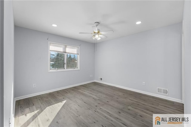 unfurnished room with baseboards, visible vents, wood finished floors, and recessed lighting