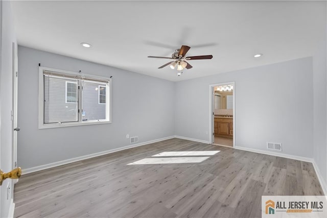 unfurnished room with light wood finished floors, baseboards, visible vents, and ceiling fan