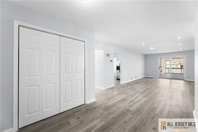 unfurnished living room featuring recessed lighting, wood finished floors, and baseboards