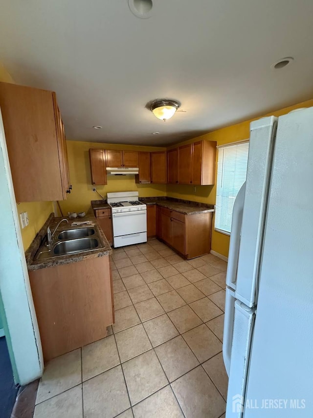 154 Townsend St, New Brunswick, NJ 08901 - kitchen featuring white appliances, light tile patterned flooring, under cabinet range hood, and dark countertops