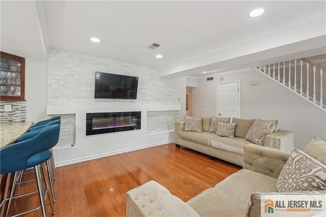 52 State Route 33rd St, Freehold Twp, NJ 07728 - living room with stairs, wood finished floors, a large fireplace, ornamental molding, and recessed lighting