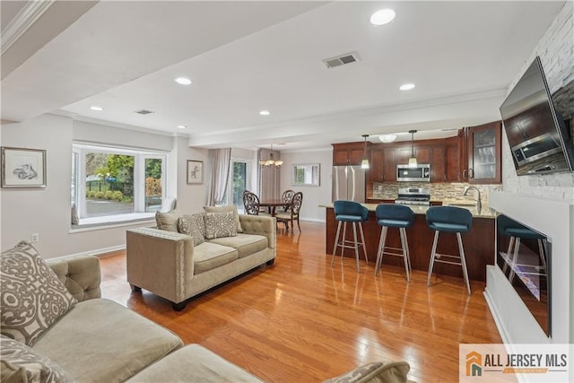 52 State Route 33rd St, Freehold Twp, NJ 07728 - living area featuring ornamental molding, a chandelier, light wood-style floors, and recessed lighting