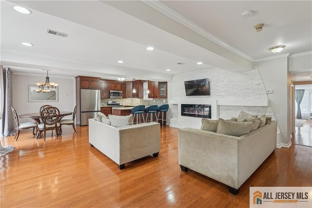 52 State Route 33rd St, Freehold Twp, NJ 07728 - living area featuring ornamental molding, light wood finished floors, a chandelier, a fireplace, and recessed lighting