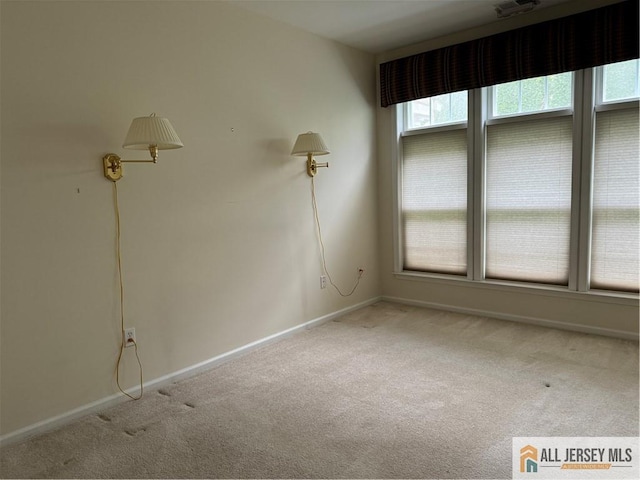 spare room featuring carpet flooring and baseboards