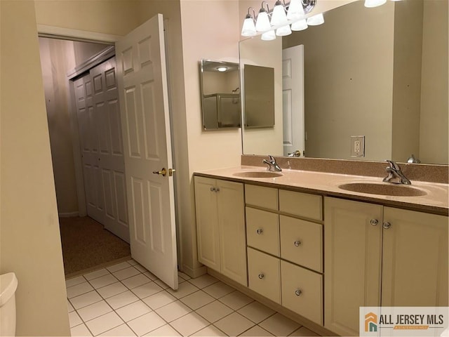 full bathroom with double vanity, tile patterned flooring, a sink, and toilet