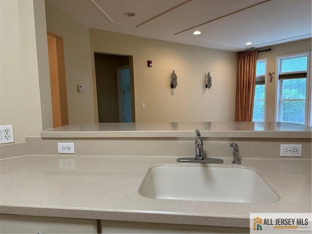 kitchen featuring light countertops, a sink, and recessed lighting