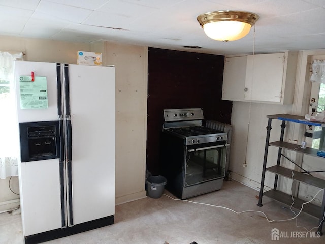 kitchen featuring white cabinets, range, and white fridge with ice dispenser