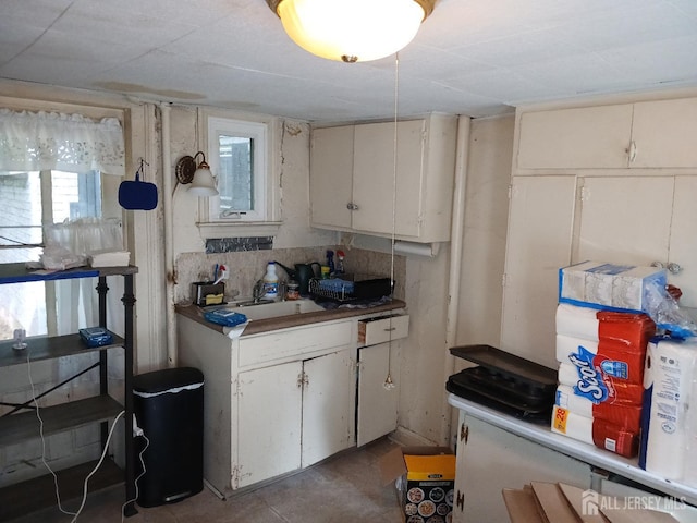 kitchen featuring white cabinetry and sink