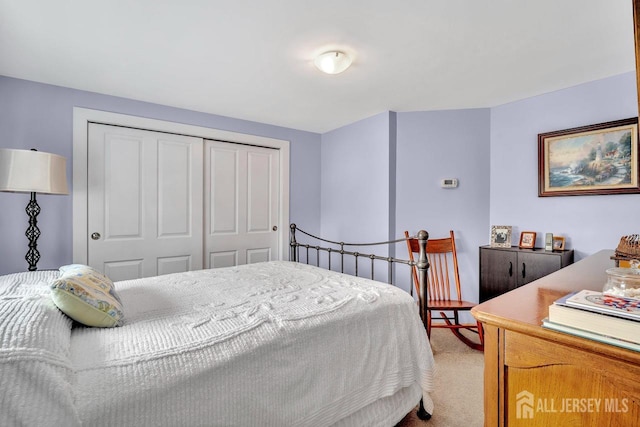 bedroom featuring a closet and light carpet