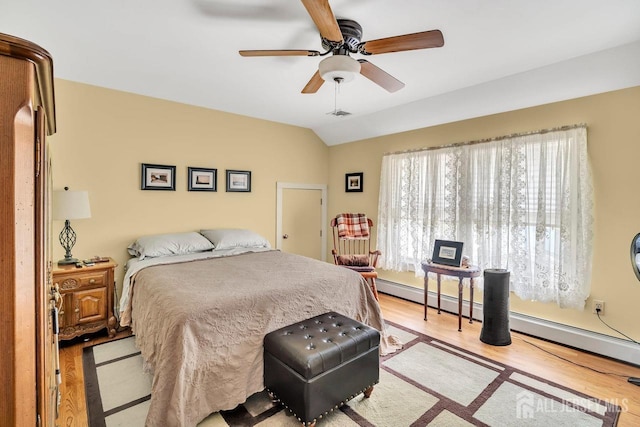 bedroom with light wood-style flooring, a baseboard radiator, vaulted ceiling, visible vents, and a ceiling fan