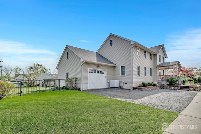 view of home's exterior featuring a lawn, gravel driveway, an attached garage, and fence