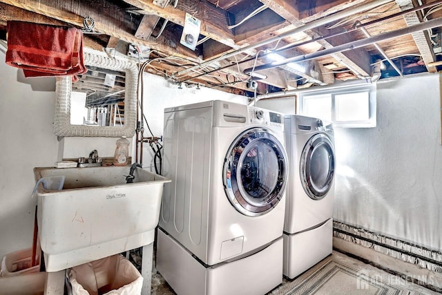 clothes washing area featuring a sink, laundry area, and washing machine and dryer
