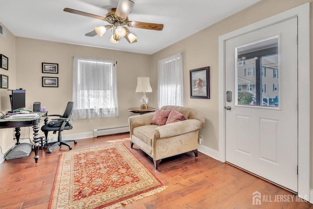 office featuring baseboards, wood finished floors, ceiling fan, and a baseboard radiator