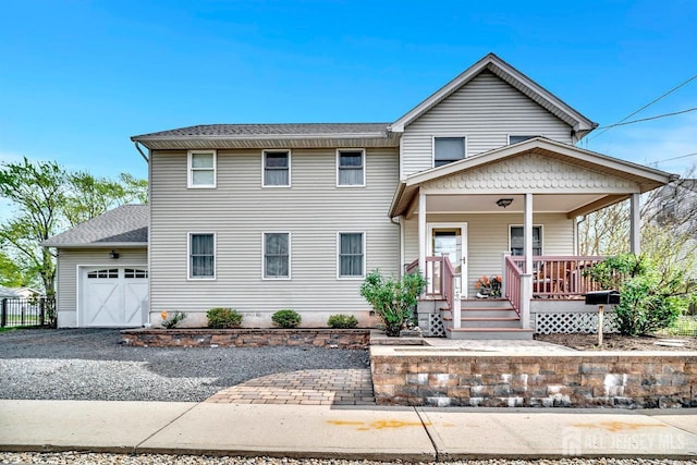 view of front of house with driveway, a shingled roof, an attached garage, and covered porch