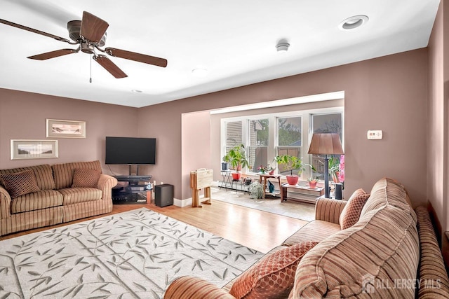 living room featuring ceiling fan, baseboard heating, baseboards, recessed lighting, and wood finished floors