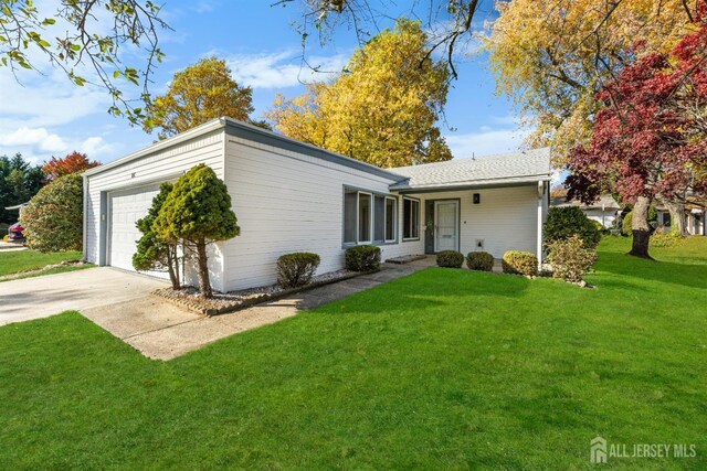 single story home featuring a garage and a front yard