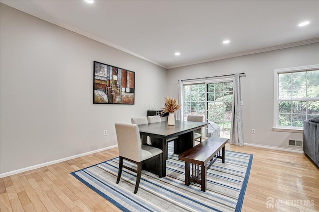 dining area featuring crown molding, light hardwood / wood-style floors, and a wealth of natural light