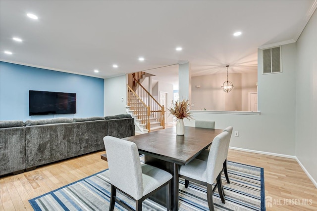 dining room featuring ornamental molding, a chandelier, and light wood-type flooring