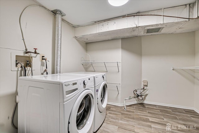 laundry area with separate washer and dryer and light wood-type flooring