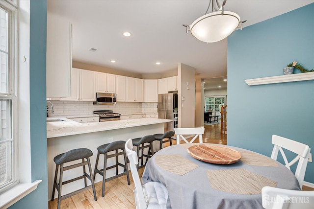 dining space featuring sink and light wood-type flooring