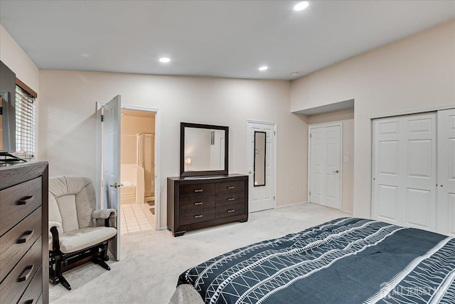 bedroom featuring light colored carpet, ensuite bath, and a closet