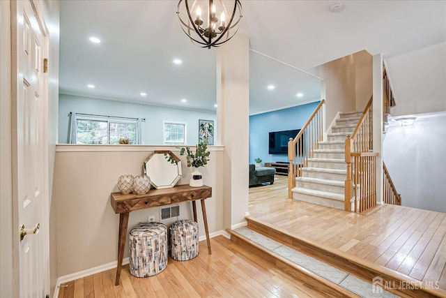 foyer featuring ornamental molding, a chandelier, and light wood-type flooring