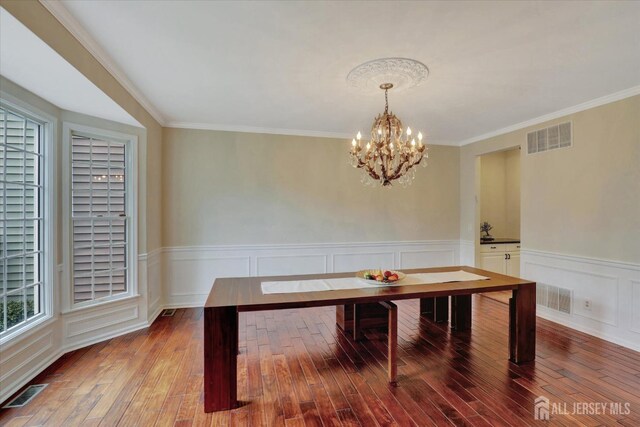 unfurnished dining area with hardwood / wood-style flooring, a healthy amount of sunlight, and ornamental molding