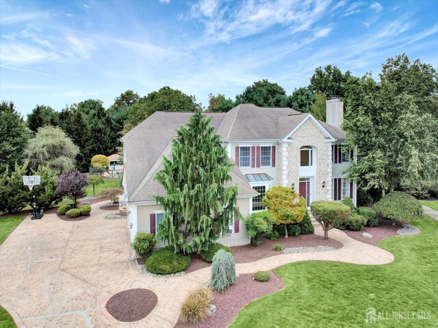 colonial home featuring a front lawn