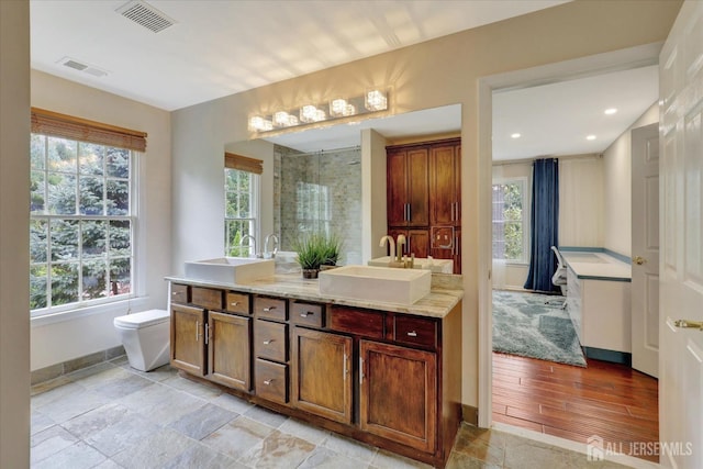 bathroom featuring hardwood / wood-style floors, vanity, a healthy amount of sunlight, and toilet