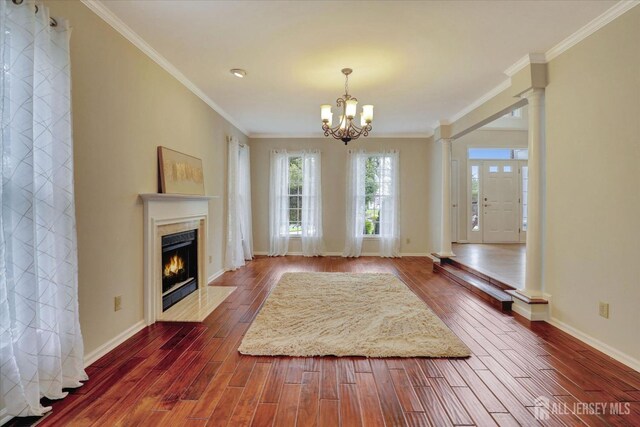 unfurnished living room with crown molding, a chandelier, and hardwood / wood-style flooring