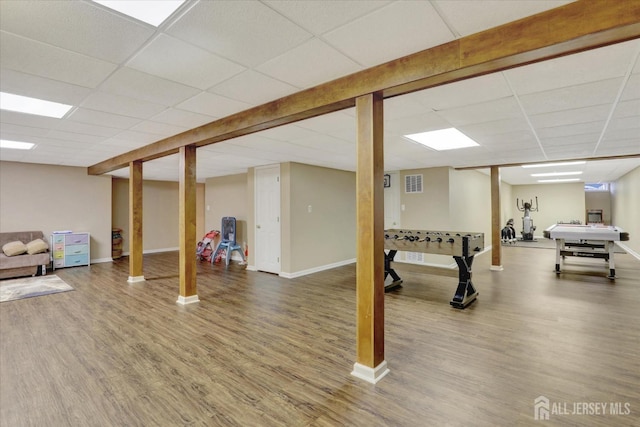 basement with a paneled ceiling and hardwood / wood-style floors