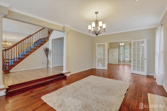 interior space with dark hardwood / wood-style flooring, french doors, and ornate columns