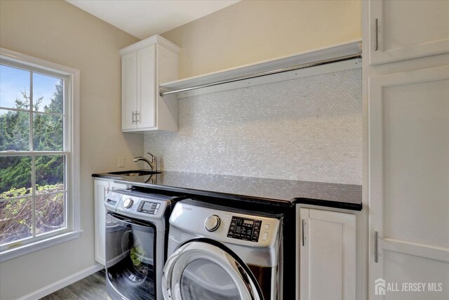 laundry room featuring cabinets, washer and clothes dryer, plenty of natural light, and sink