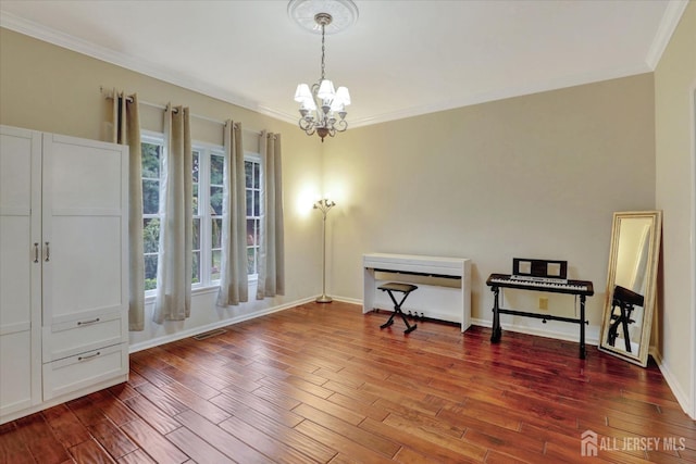 misc room with hardwood / wood-style floors, ornamental molding, and a notable chandelier