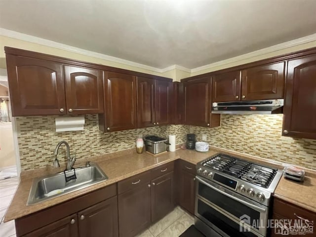 kitchen with light tile patterned floors, sink, stainless steel range, and tasteful backsplash