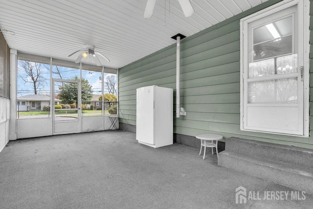 unfurnished sunroom with a ceiling fan