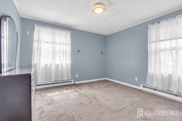 empty room with a baseboard radiator, carpet flooring, a textured ceiling, crown molding, and baseboards