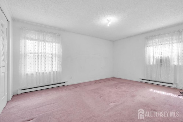 carpeted empty room featuring a baseboard heating unit, a baseboard radiator, and a textured ceiling