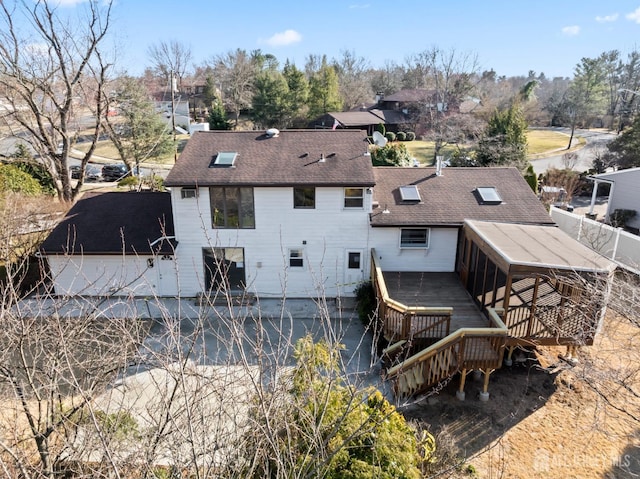 back of house with a deck and a shingled roof