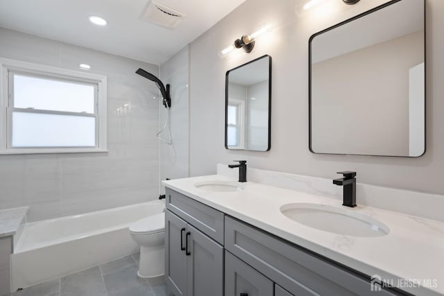 full bath featuring double vanity, toilet, tile patterned floors, and a sink