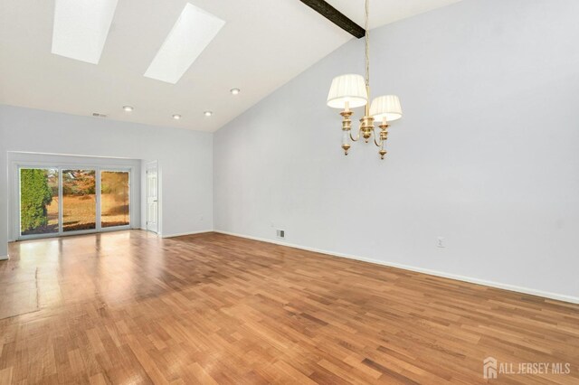 unfurnished living room with beam ceiling, a skylight, high vaulted ceiling, and light hardwood / wood-style floors