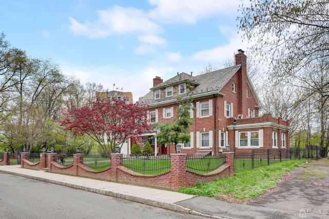 view of front of home featuring a fenced front yard, a front yard, brick siding, and a chimney