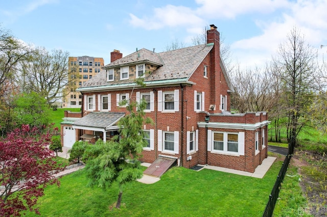 view of front facade featuring a front lawn, a high end roof, brick siding, and a chimney